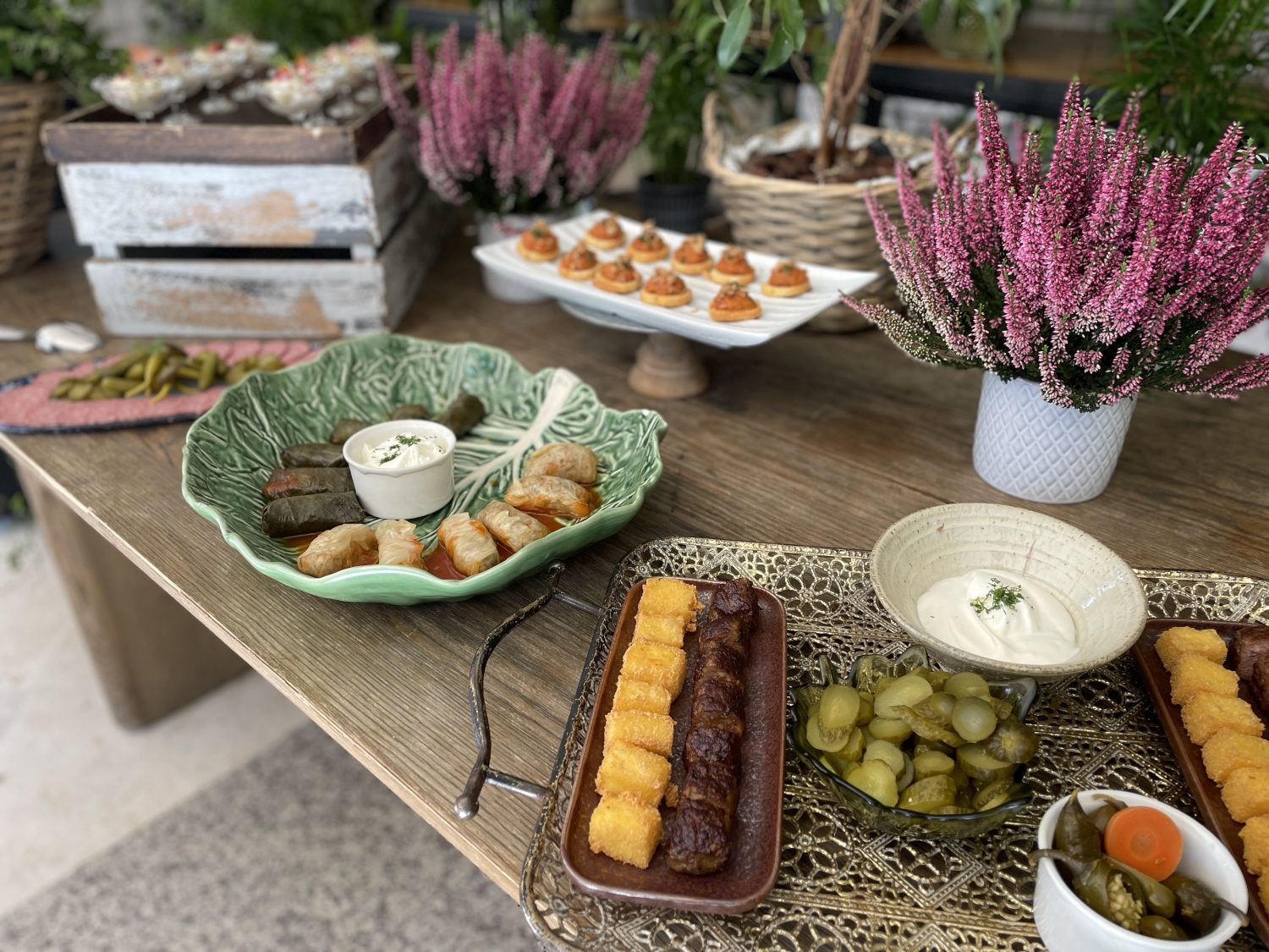 Estación de comida rumana incluyendo dolmas y brochetas de carne con salsas artesanales para el evento crisol de sabores en La Quinta de Jarama