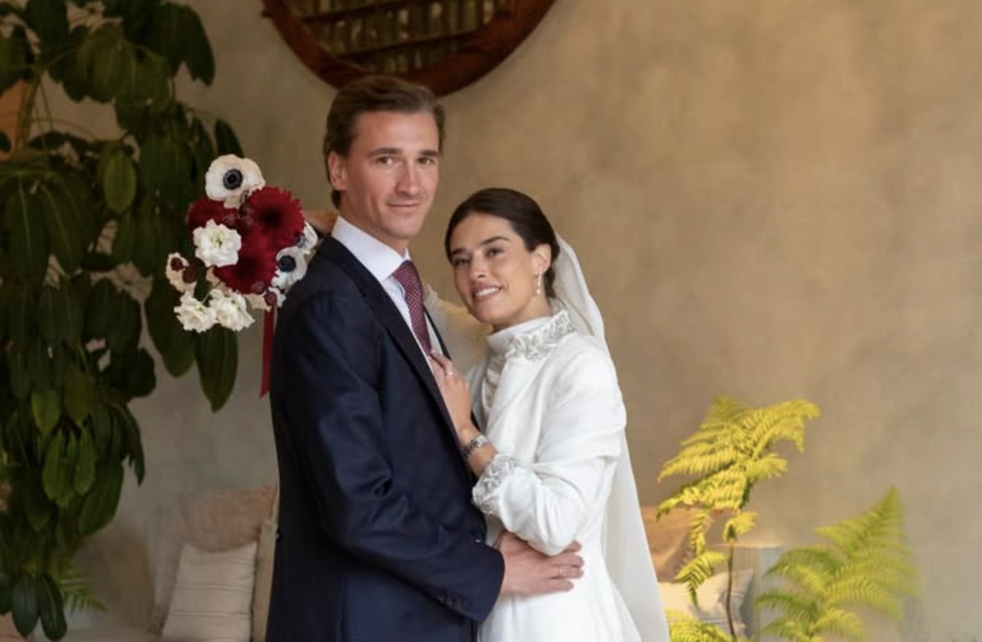 Novios posando abrazados en un espacio interior de La Quinta de Jarama, con decoración vegetal y luz cálida, tras la celebración de su boda
