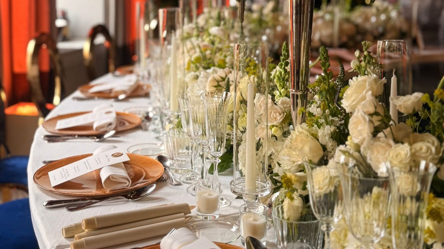 Mesa decorada con flores blancas y velas en la boda de Isabella y Santiago en La Quinta de Jarama.
