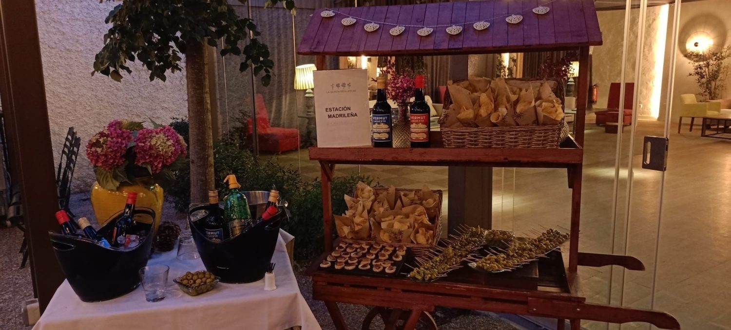 Bodegón de aperitivos en la Estación Madrileña con botellas de vermut en hielo, banderillas de aceitunas y cucuruchos de patatas para cóctel de boda
